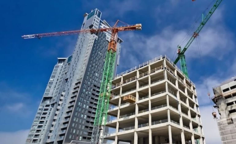 Vinçlerin çevrelediği yüksek katlı bir inşaat projesi