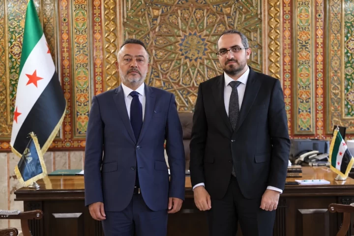 Şam Büyükelçisi Nuh Yılmaz ve Suriye Yatırım Ajansı Başkanı Rawad Ramadan, görüşme sırasında yan yana duruyor.