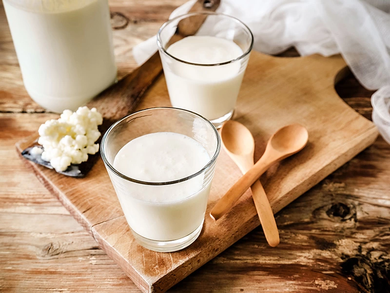 Tahta servis üzerinde bardaklarda yoğurt ve kefir