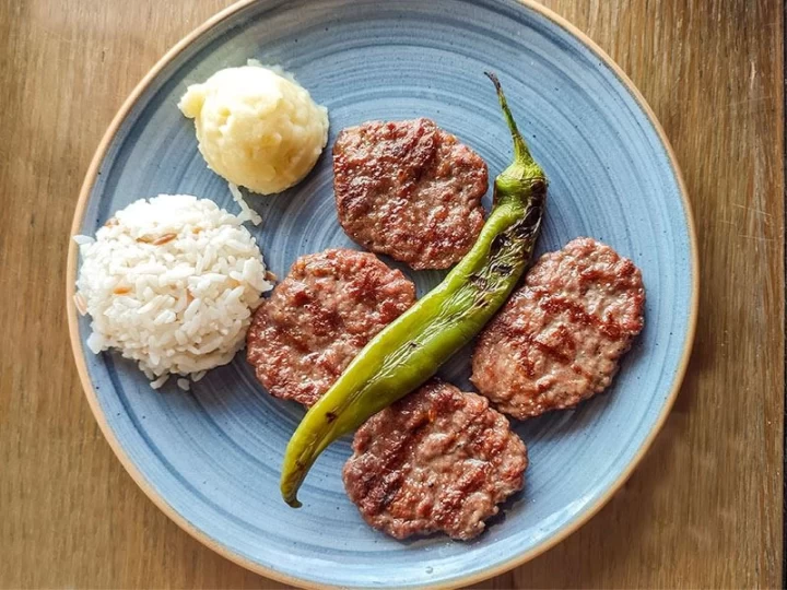 Mavi tabakta pilav, közlenmiş biber ve köfteler