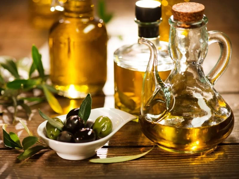 Cam yağ kapları ve zeytinlerin bulunduğu masa